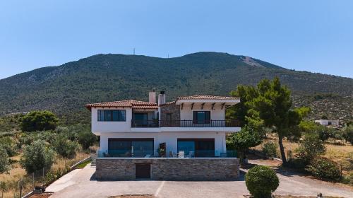 a house on a hill with a mountain in the background at Villa Panorama Serenity 