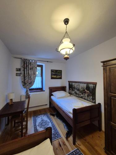 a bedroom with a bed and a desk and a lamp at Rábagyarmati Apartman in Rábagyarmat