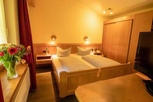 a hotel room with a bed and a television at Hotel Edelsberg in Untergschwend