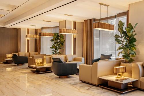 a lobby of a hotel with couches and plants at ME Malta by Meliá in St Julian's