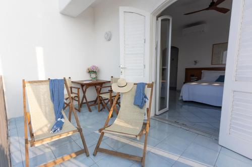 a room with two chairs and a table and a bed at Hotel Punta Scario in Malfa