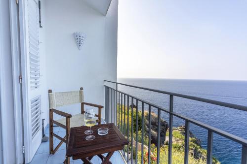 a balcony with a table and a view of the ocean at Hotel Punta Scario in Malfa