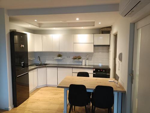 a kitchen with a wooden table and black appliances at Apartament Maria in Oświęcim
