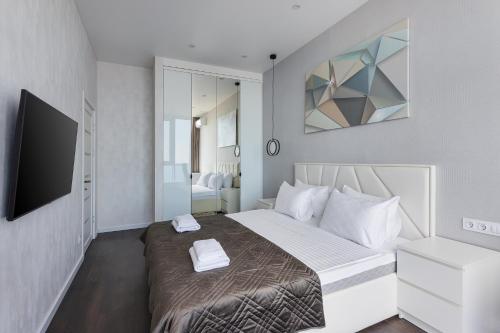 a bedroom with a bed and a television in it at Sea Pearl 1Line in Odesa