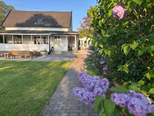 a house with a garden and flowers in the yard at Charming Cottage near Beach & Nature in Sarpsborg