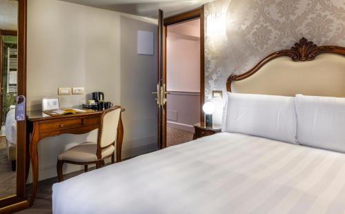 a hotel room with a bed and a desk at Hotel Colombina in Venice