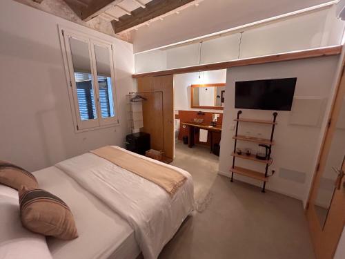 Un dormitorio con una cama, un escritorio y un televisor. en Smoix hotel, en Ciutadella