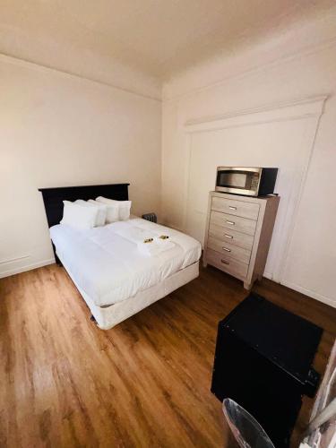 a bedroom with a white bed and a microwave at Riviera Hotel in San Francisco
