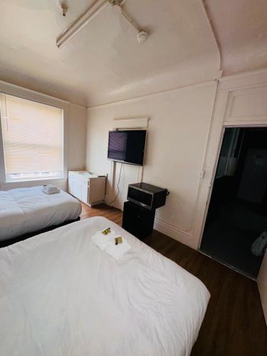 a hotel room with two beds and a flat screen tv at Riviera Hotel in San Francisco