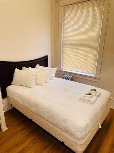 a bedroom with a large white bed with a window at Riviera Hotel in San Francisco