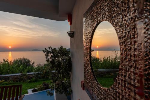 a mirror on the side of a building looking at the sunset at Hotel Punta Scario in Malfa