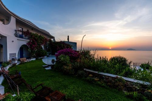 a house with a yard with a view of the water at Hotel Punta Scario in Malfa