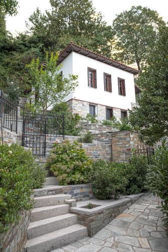 a house with stairs in front of a building at Christoforos' Villa Sea View in Agios Ioannis Pelio