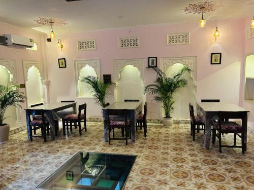 a dining room with tables and chairs and plants at House of Amer in Jaipur