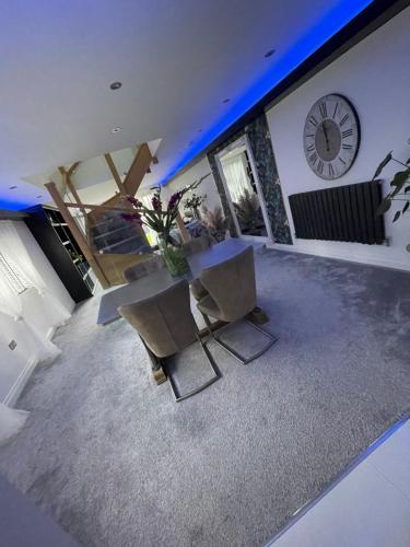 a living room with a table and a clock on the wall at The hidden barn in Easington