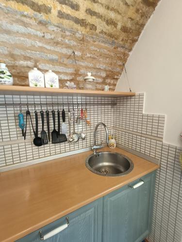 a kitchen counter with a sink and a shelf with utensils at Il nido del Poeta in Recanati