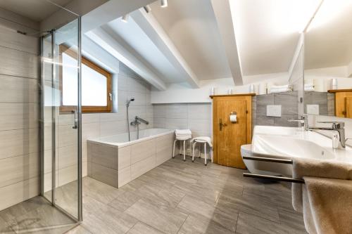 a bathroom with a tub and a sink at Appartementanlage Kerber in Seefeld in Tirol