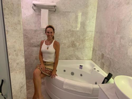 a woman sitting on a tub in a bathroom at Ürgüp Inn Cave Hotel in Urgup