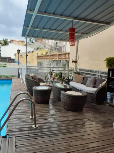 a patio with a couch and chairs and an umbrella at Villa Soazara in Koungou