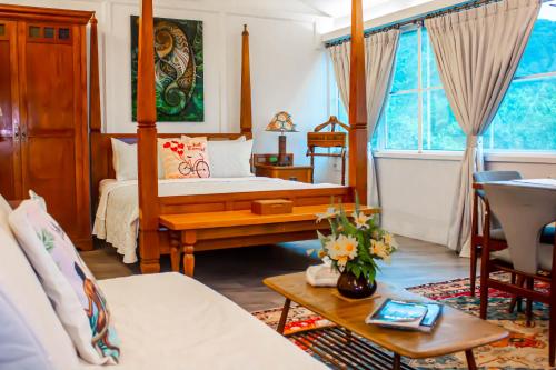 a living room with a bed and a table and a room at Sinurambi Cottage Rental in Penampang