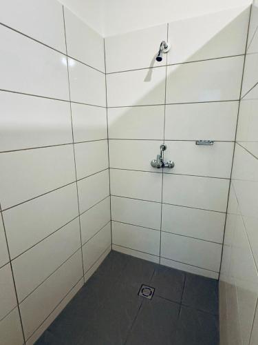 a shower room with white walls and a shower at NUMBR25 - self service & low budget Hotel in Graz