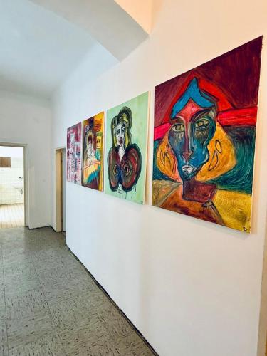 a row of paintings on a wall in a hallway at NUMBR25 - self service & low budget Hotel in Graz