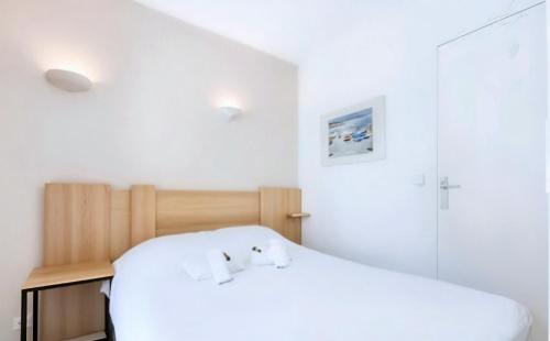 - une chambre avec un lit blanc et des draps blancs dans l'établissement FRGK 