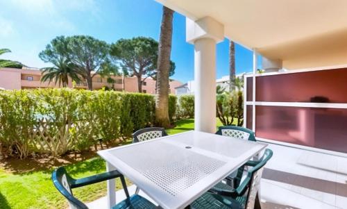 une table blanche et des chaises sur une terrasse dans l'établissement FRGK 