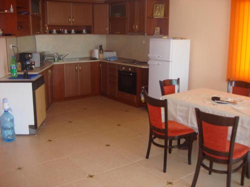 eine Küche mit einem Tisch und einem weißen Kühlschrank in der Unterkunft Villa Sunray in Topola
