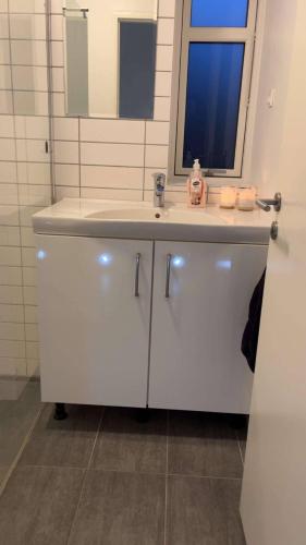 a bathroom with a white sink and a mirror at Cozy New Apartment in Vejle City Center in Vejle