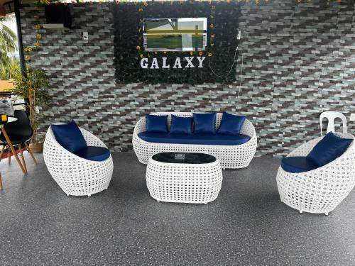 four wicker chairs and a table in a room at Galaxy Family Room in Dalaguete