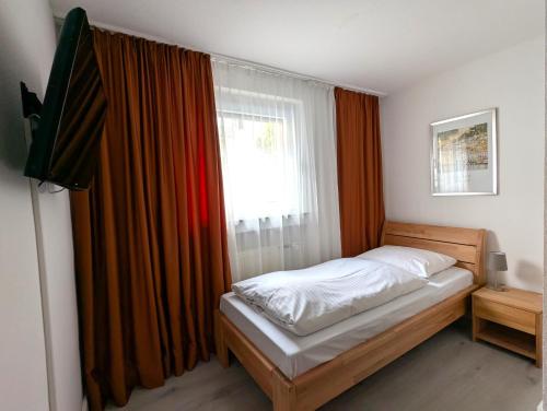 a small bedroom with a bed and a window at City Hotel Stuttgart in Stuttgart