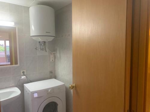 une salle de bains avec lave-linge et lavabo dans l'établissement APCOSTAS Ses Illes, à Blanes