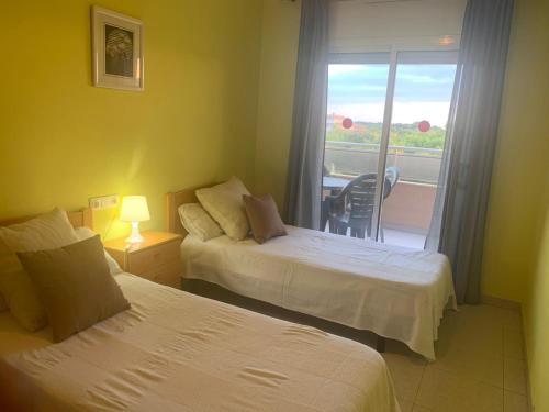 une chambre d'hôtel avec deux lits et un balcon dans l'établissement APCOSTAS Ses Illes, à Blanes