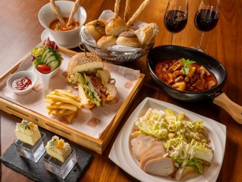 a wooden table with plates of food and glasses of wine at Ramada Plaza by Wyndham Sanya Bay in Sanya