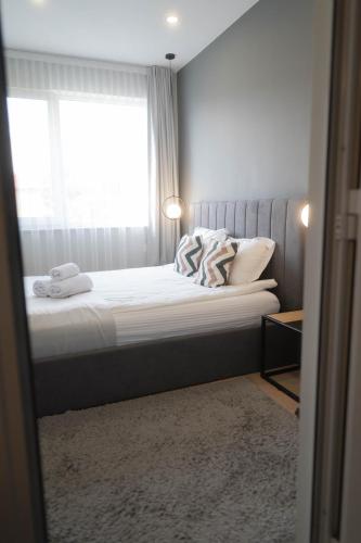a small bedroom with a bed with a window at "The House" Апартаменти и Термална зона in Velingrad