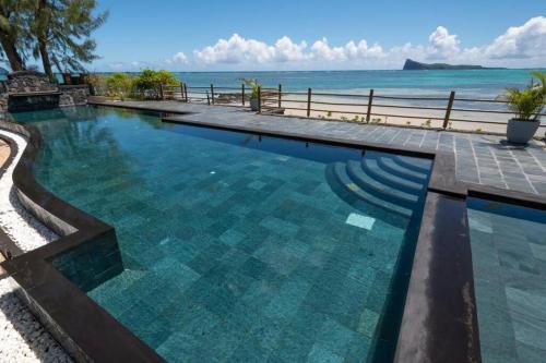 a swimming pool with a view of the ocean at Luxury Oceanfront Apt with Private Pool - 3BR in Bain Boeuf