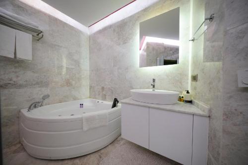 a white bathroom with a tub and a sink at Ürgüp Inn Cave Hotel in Urgup