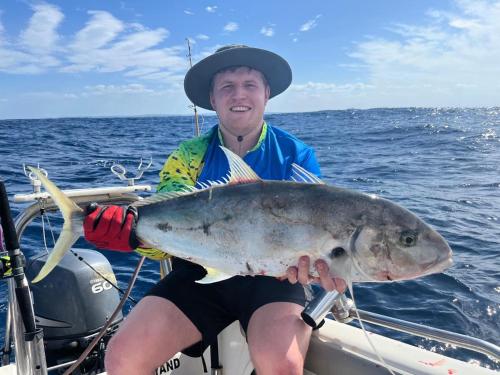 a man on a boat holding a large fish at Linga Bay Retreat in Morrumbene