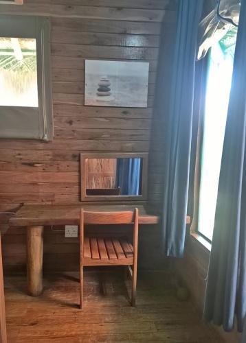 a wooden desk with a bench and a window at Linga Bay Retreat in Morrumbene