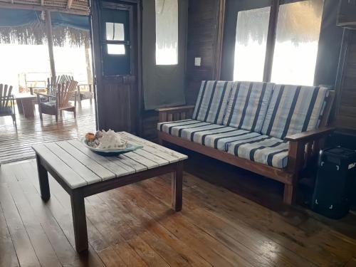 a living room with a bench and a table at Linga Bay Retreat in Morrumbene