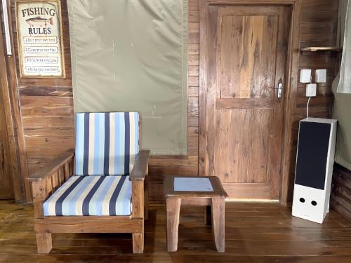 a wooden room with a chair and a speaker at Linga Bay Retreat in Morrumbene