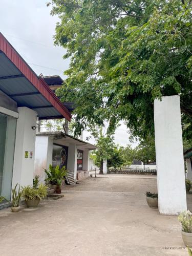 an empty parking lot next to a building with a tree at Riverside Hotel in Katunayake
