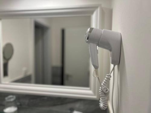 a phone hanging on a wall in front of a mirror at Hotel Garden Court in Prague