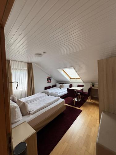 a hotel room with two beds and a table at Haus Mechthild Sindelfingen-Maichingen Self Check-In in Sindelfingen