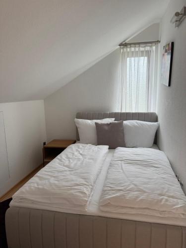 a large white bed in a room with a window at Haus Mechthild Sindelfingen-Maichingen Self Check-In in Sindelfingen