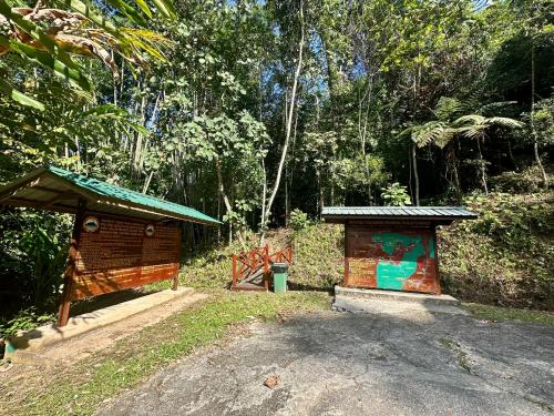 a small building next to a road in a forest at Sinurambi Cottage Rental in Penampang