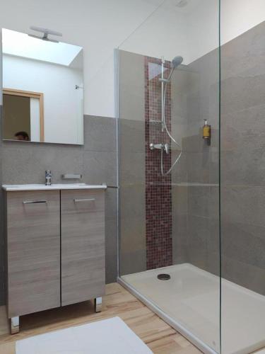 a bathroom with a glass shower and a sink at Gite le crespin in Antrenas