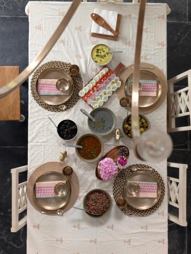 a table with bowls and plates of food on it at Jaadooghar The Chitai Life in Almora