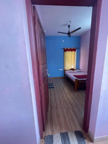 a room with a bedroom with a bed and a ceiling fan at HostelExp, Varkala - A Beach Town Hostel in Varkala